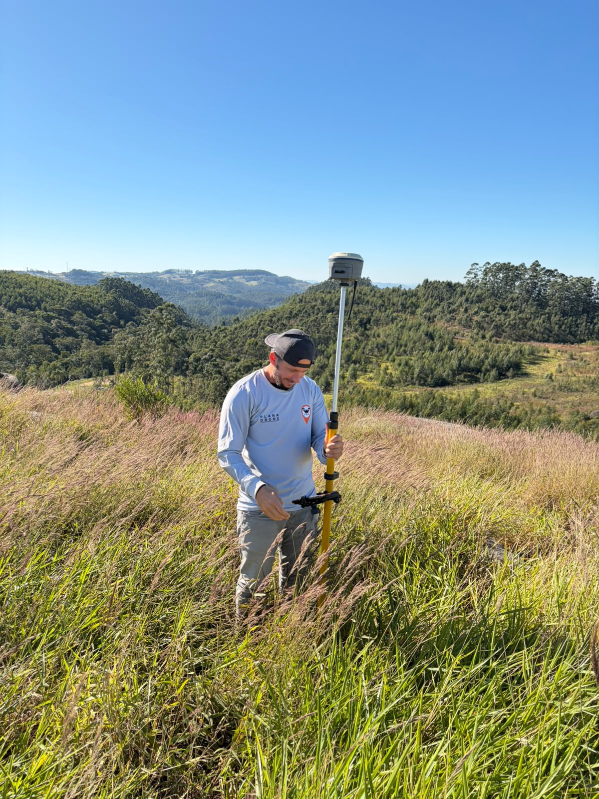 Vinicius em campo com receptor GNSS em área rural